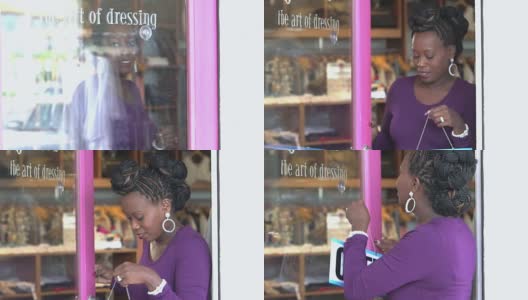黑人妇女在服装店门口挂着开门的牌子高清在线视频素材下载
