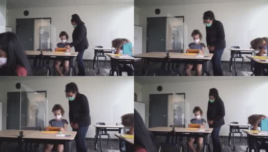 老师在COVID-19课堂上帮助学生高清在线视频素材下载