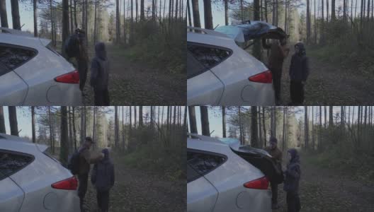 一位中年男子和他的儿子在森林里从汽车后备箱里取出背包高清在线视频素材下载