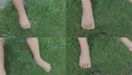 夏天的时候，小娃娃踩在绿色的草地上。赤足儿童特写视图高清在线视频素材下载
