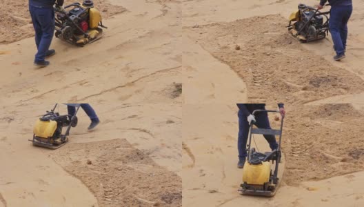 施工人员用振动板夯实机在施工现场夯实砂后进行铺装高清在线视频素材下载