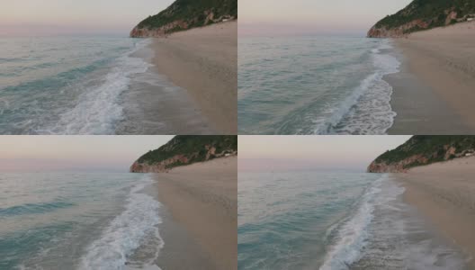 鸟瞰希腊爱奥尼亚岛莱夫卡达美丽的米洛斯海滩。夕阳金色的阳光和原始的海浪打破了蓝绿色的大海在岸边高清在线视频素材下载