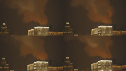 夜晚的城市里，浓重的蒸汽笼罩着建筑物。街道上的老式酒店灯火通明。外部装饰。冬季假期。4 k的片段高清在线视频素材下载