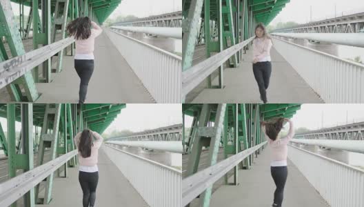 年轻女子在桥下行走高清在线视频素材下载