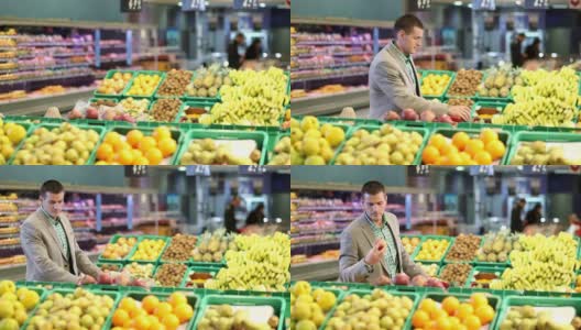 超市水果柜台旁推着手推车的人高清在线视频素材下载