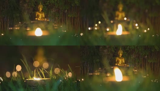 金佛在禅坐姿势与草和蜡烛高清在线视频素材下载