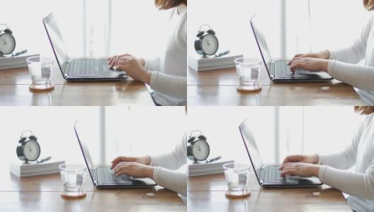 在家里工作的妇女，用她的笔记本电脑在木桌上打字，多莉从右向左射击高清在线视频素材下载
