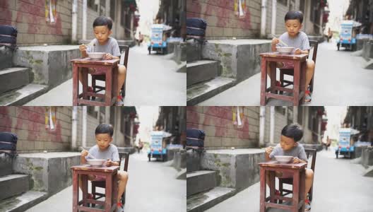 快乐的亚洲孩子用筷子吃美味的面条高清在线视频素材下载