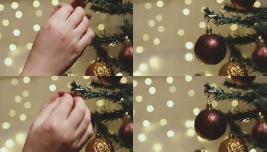 圣诞快乐，恭贺新禧。女性的手用酒红色的球和玩具装饰圣诞树，在装饰好的房子里准备新年假期。高清在线视频素材下载
