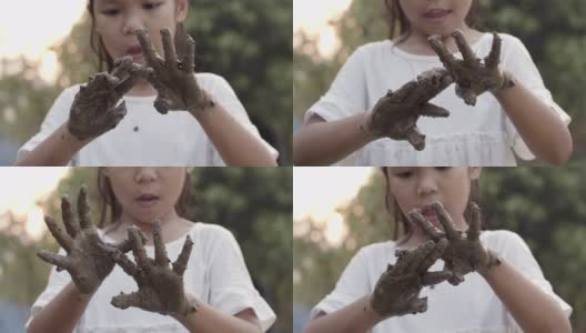 亚洲女孩在植树后玩泥巴和展示脏手高清在线视频素材下载