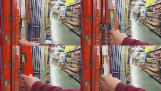 一名男子在一家建材商店选择了一个建筑气泡层来夷平墙壁，特写镜头高清在线视频素材下载