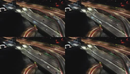 夜间空中立交桥交通拥堵立交道路，夜间无人机拍摄下现代城市道路交叉口的俯视图。许多汽车在繁忙的十字路口高速公路快速行驶高清在线视频素材下载
