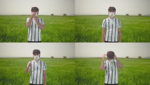 一个年轻男子的肖像与休闲服装在绿色的田野戴着防护面具。高清在线视频素材下载
