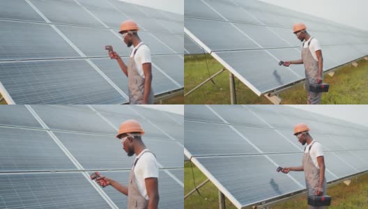 男性手持电子热成像仪近太阳电池户外的特写。非裔美国技术员控制站内光伏板温度高清在线视频素材下载