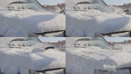 在一个阳光明媚的冬日，用手刷清除车上的积雪高清在线视频素材下载