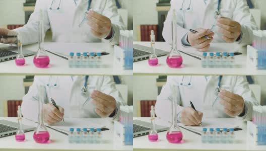 一个医生的手在试管里拿着疫苗样本的特写——他正在实验室里写报告。研究开发现代疫苗高清在线视频素材下载