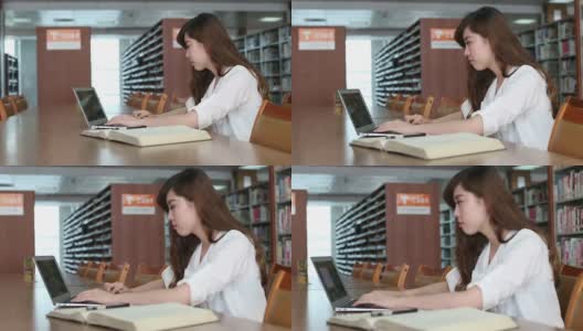 中国女学生在图书馆使用笔记本电脑，实时。高清在线视频素材下载