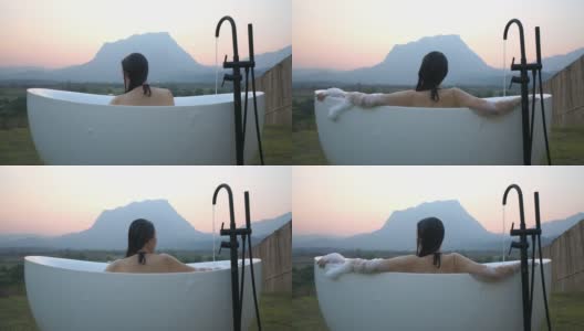 亚洲女人放松在户外沐浴与山景在前面高清在线视频素材下载