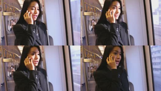 一个年轻的亚洲女人在火车上聊天。高清在线视频素材下载