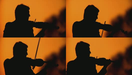 一个小提琴家在日落时的剪影高清在线视频素材下载