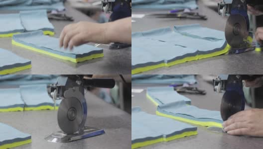 电动裁布机。一个人在缝纫车间裁剪织物的手。工作室高清在线视频素材下载