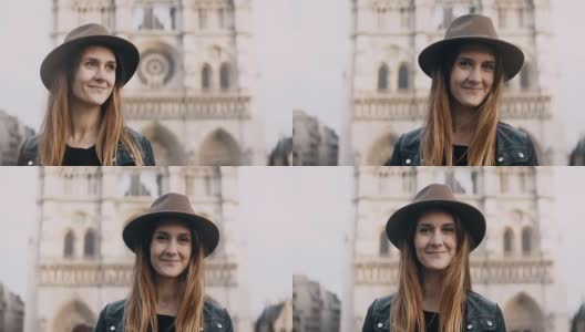 在巴黎圣母院附近的年轻美丽的女人戴着帽子的肖像，法国。女性看着镜头微笑高清在线视频素材下载