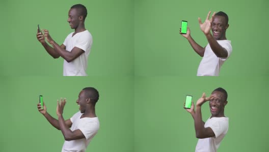 年轻的非洲男子用绿色背景的手机视频通话高清在线视频素材下载