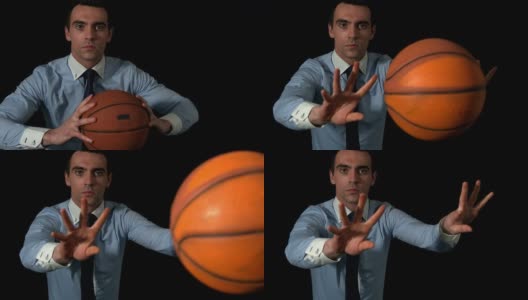 商人在黑色背景下向摄像机投篮球高清在线视频素材下载