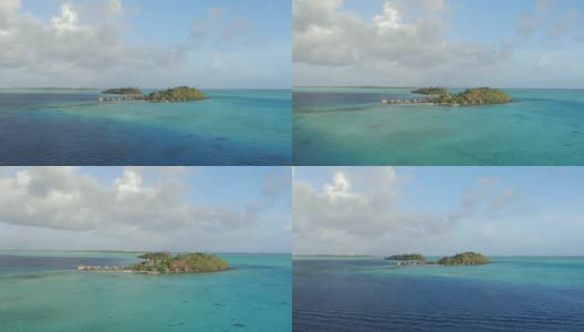 航拍:在美丽的夏日，飞往拥有豪华水上平房的私人岛屿上的完美度假酒店高清在线视频素材下载