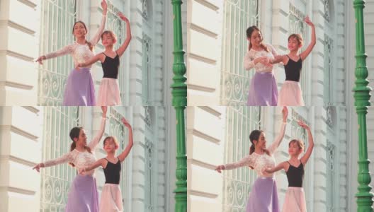 在一个阳光明媚的日子里，一名亚洲青少年芭蕾舞演员在一名年轻女芭蕾舞老师的建议下，在泰国曼谷当地的街道上练习芭蕾舞。活跃的年轻妇女和孩子的概念周末活动和当地地标。高清在线视频素材下载