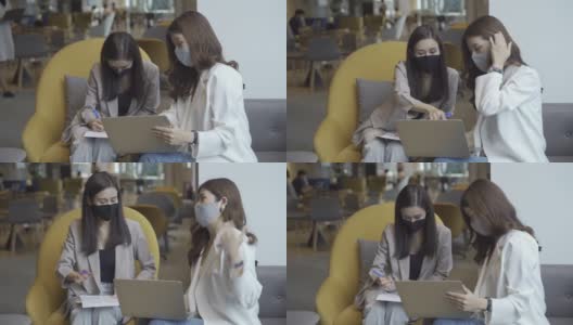 两位在办公室使用笔记本电脑开会的亚洲商务女性戴着医用口罩在办公室工作高清在线视频素材下载