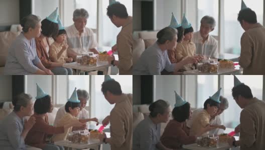 亚洲华人多代家庭庆祝生日，用菜刀切生日蛋糕高清在线视频素材下载