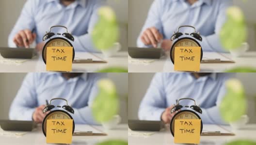闹钟上有税务时间提示的商人高清在线视频素材下载