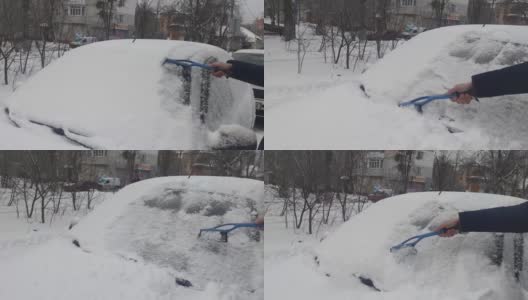 旅行前清洗汽车玻璃上的冰雪。一名男子从车窗上取雪。在霜雪的冬天，一名男子用特殊工具清洁汽车。高清在线视频素材下载