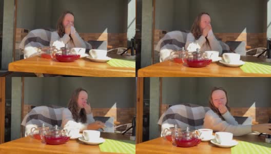 季节性过敏的女孩十几岁，在春天的桌子上擤鼻涕，旁边是致敏茶高清在线视频素材下载