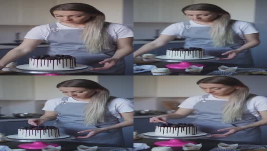 年轻可爱的女人糕点厨师准备生日蛋糕装饰在家里的厨房浆果小生意，自制糕点厨师视频高清慢动作高清在线视频素材下载
