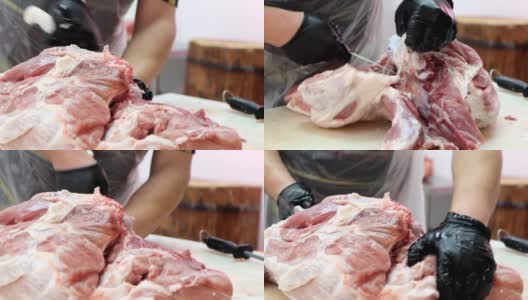 屠夫在肉类加工厂从猪肉身上切骨头。高清在线视频素材下载