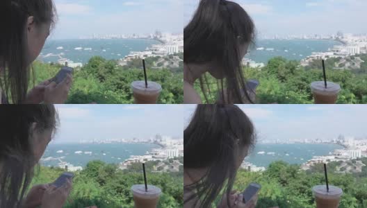 亚洲美丽的女孩使用智能手机海景高清在线视频素材下载