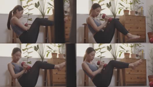 漂亮的年轻女子在家用哑铃锻炼高清在线视频素材下载