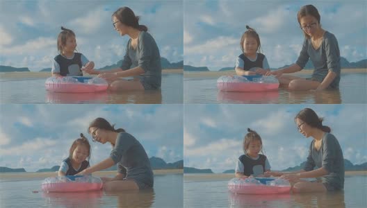 亚洲年轻母亲和小女儿在海滩上玩耍高清在线视频素材下载