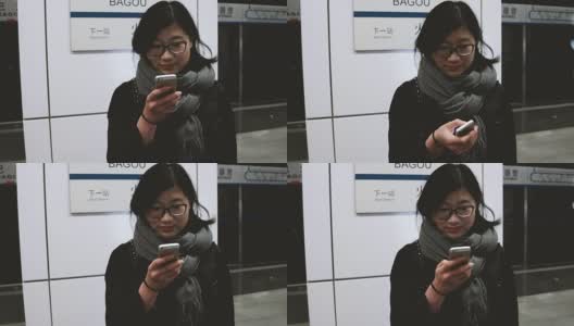 亚洲女孩在地铁站使用手机/北京，中国高清在线视频素材下载