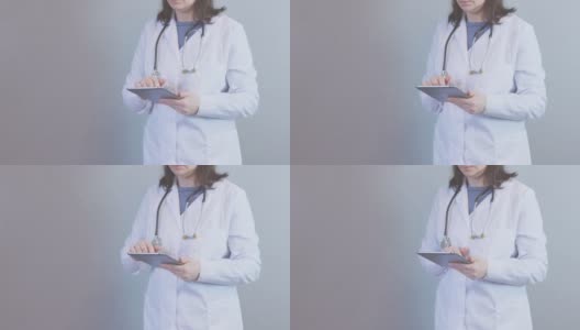女医生白色制服，听诊器，使用数码平板，触摸手指高清在线视频素材下载