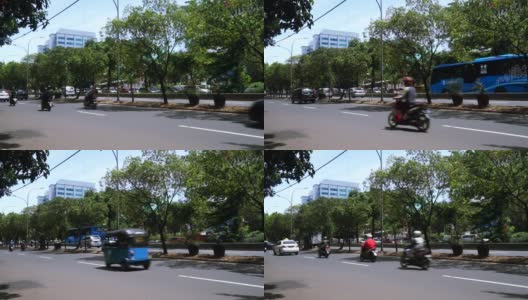 印度尼西亚雅加达市中心，绿色的树木和汽车、摩托车在道路上高清在线视频素材下载