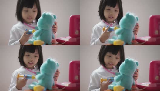 亚洲华人幼童玩假装医生与她的泰迪熊的特写高清在线视频素材下载