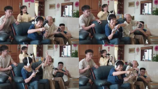 2名亚裔中国祖父母在家里和孙辈玩电子游戏。高清在线视频素材下载