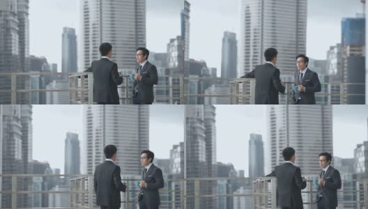 2位亚洲华人白领西装革面，在办公楼阳台上休息聊天高清在线视频素材下载