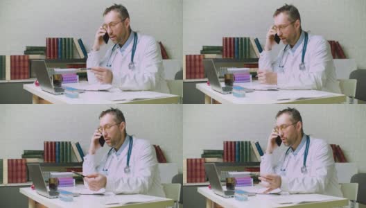 Dolyy拍摄的是一位中年医生正在和一位病人通电话。他告诉他关于他的诊断和保险的细节高清在线视频素材下载