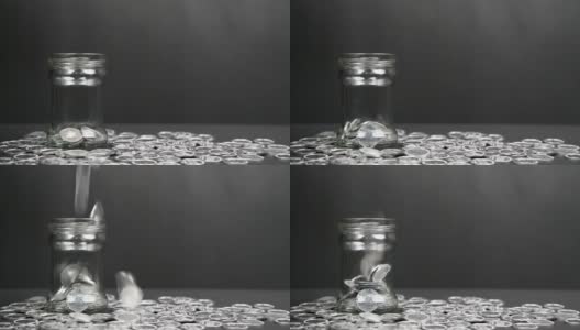 硬币从上面迅速落入一个玻璃罐中高清在线视频素材下载