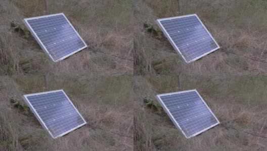 一个安装在草地上的便携式小型光伏太阳能电池板。4K高清在线视频素材下载