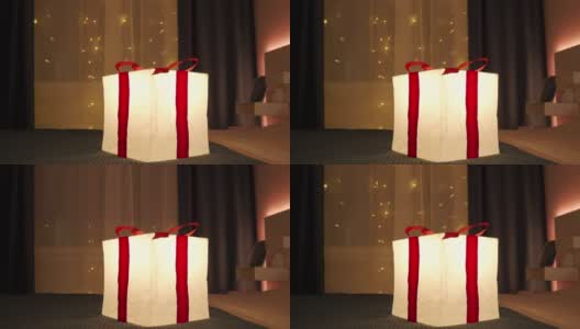 在夜晚，礼品盒灯的灯光照亮了装饰过的房间。生日、圣诞节、新年喜庆彩灯。高清在线视频素材下载